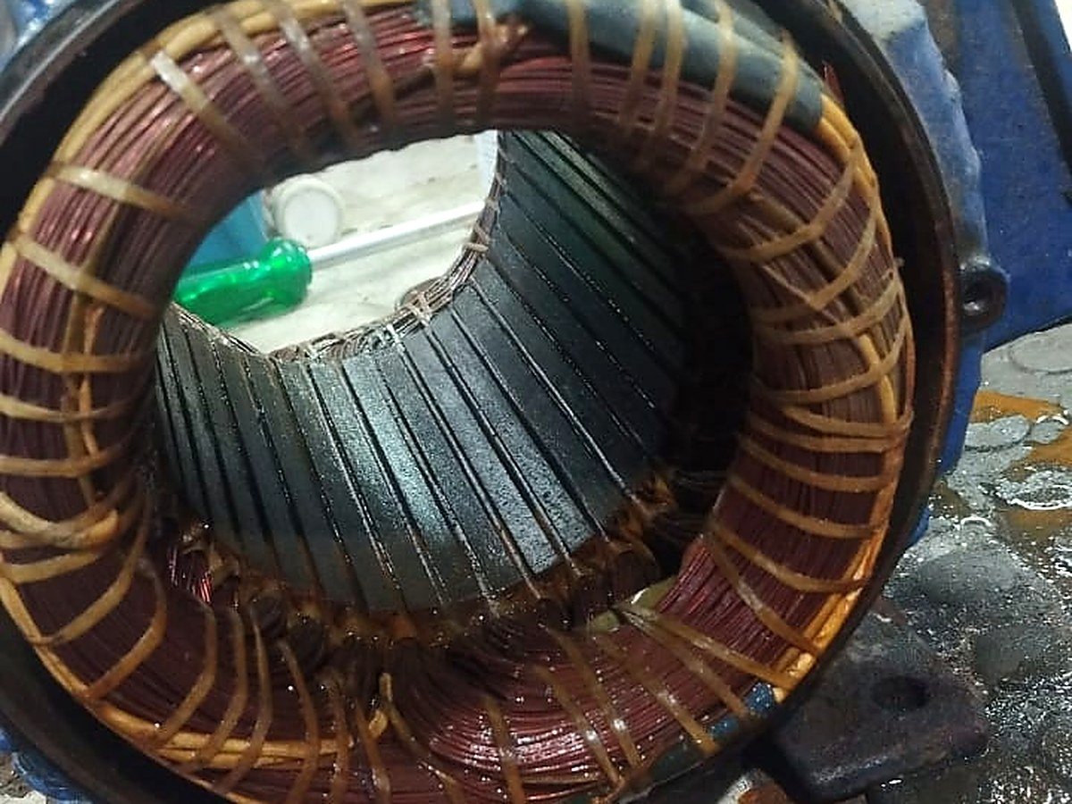 Bobina do estator de um motor de bomba aberta na bancada para inspeção do enrolamento