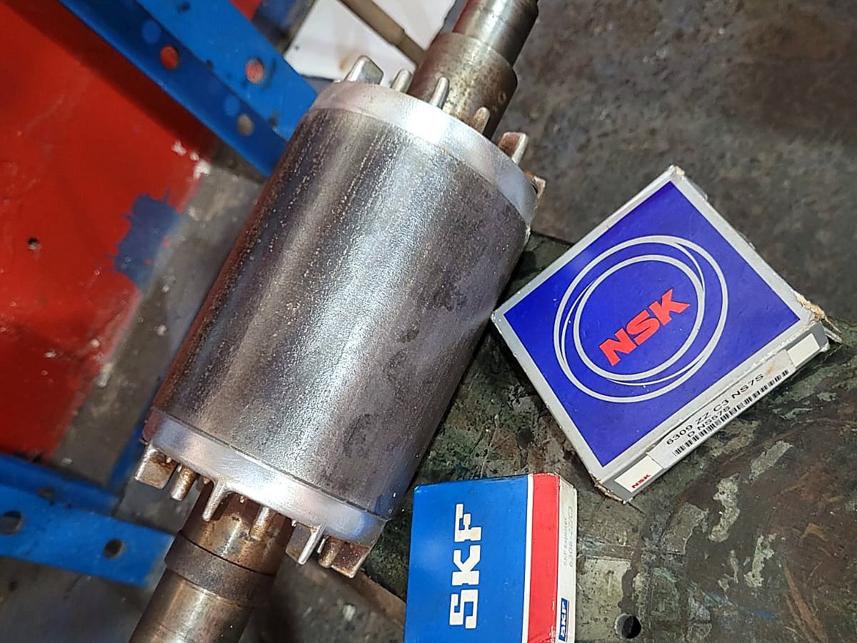 Eixo e rotor de bomba na bancada ao lado de rolamentos novos ainda nas caixas, prontos para a montagem